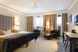 a hotel room with a bed and a desk and chairs at Elite Stadshotellet Luleå in Luleå
