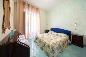 a bedroom with a bed and a dresser and a window at casa la perla in Minori