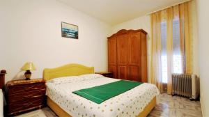 a bedroom with a bed and a dresser and a window at Apartment Glomazic in Budva