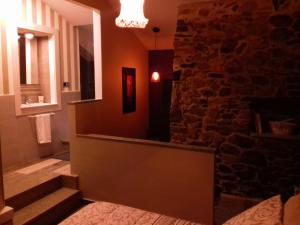 um quarto com uma parede de pedra e uma escada em Casa Mara-Pidre em Corunha
