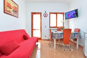 Apartment Ljiljana 1553 في نوفيغراد استريا: غرفة معيشة مع أريكة حمراء وطاولة