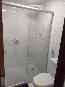 y baño con ducha de cristal y aseo. en Terrazzas 209, en João Pessoa