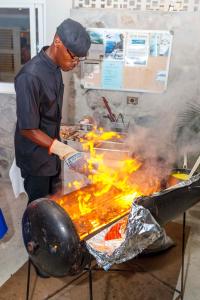 a man is cooking food on a grill at Blue Lagoon Hotel and Marina Ltd in Kingstown