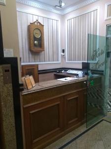 a room with a counter with a clock on the wall at Hotel Macabu in Barra Mansa
