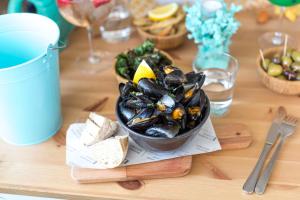 a table topped with a bowl of mussels and cheese at Lulworth Lodge in Lulworth Cove