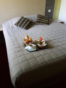 a bed with two pillows and a tray of food at Hotel Du Golf in Cabourg