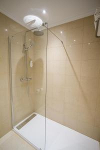 
a bathroom with a shower stall with a glass shower door at Hotel Don Pepe in Ribadesella
