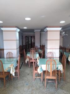 a dining room with tables and chairs in a room at Hotel Macabu in Barra Mansa
