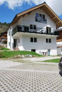 ein weißes Haus mit einem Balkon und einem Kopfstein in der Unterkunft Haus Kissel in Saalbach-Hinterglemm