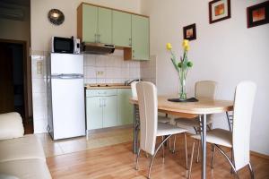una cucina con tavolo, sedie e frigorifero di Apartments Čule a Rab