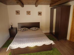 a bedroom with a bed with a wooden headboard at Oma's Hutte in Cărpiniş +71 photos
