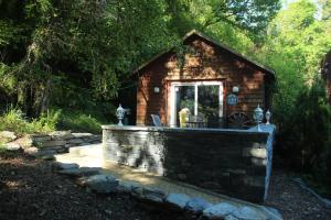 a small brick cabin with a table and chairs in it at Lledr House Hostel near two Zip World sites in Dolwyddelan