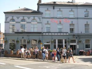 Un gruppo di persone che camminano davanti a un edificio di Wimbledon Views a Londra