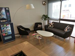 a living room with a couch and a table and a refrigerator at Hotel Europa de Figueres in Figueres