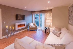 a living room with a couch and a fireplace at Riverside Retreat - Durham in Durham