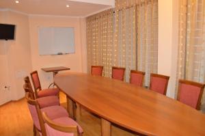 a meeting room with a wooden table and chairs at Hotel Drama Burgas in Burgas