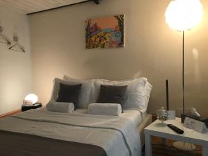 uma cama com lençóis brancos e almofadas num quarto em Stardust - Bedbluesky em Dolceacqua