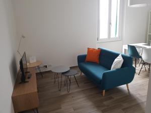 a living room with a blue couch and a table at memeapartments in Genoa