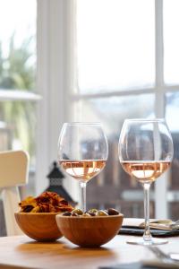 two glasses of wine and a bowl of food on a table at Lulworth Lodge in Lulworth Cove