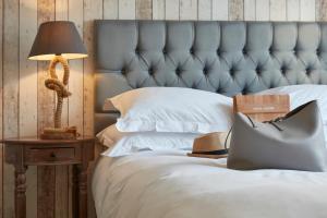 a bed with a blue headboard and a lamp on a table at Lulworth Lodge in Lulworth Cove