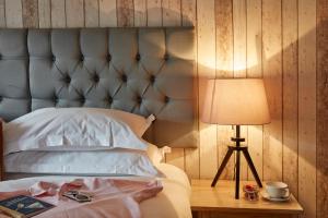 a bed with a headboard and a table with a lamp at Lulworth Lodge in Lulworth Cove