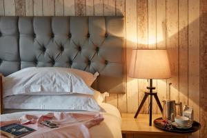 a bed with a blue headboard and a table with a lamp at Lulworth Lodge in Lulworth Cove
