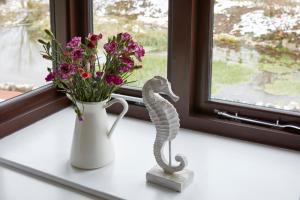 a statue of a snake next to a vase of flowers at Lulworth Lodge in Lulworth Cove