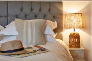 a hat sitting on top of a bed next to a lamp at Lulworth Lodge in Lulworth Cove
