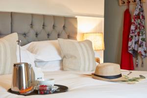 a tray with a hat and a tea kettle on a bed at Lulworth Lodge in Lulworth Cove