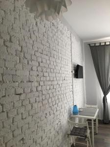 a room with a white brick wall and a table at Ametyst Apartments in Krakow