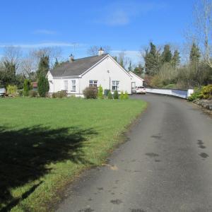 una casa con una carretera delante de un patio en Bonnieview en Glenross