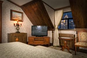 a bedroom with a television and a bed and a window at Boutique Hotel Traditional in Astana