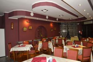 a dining room with tables and chairs in a restaurant at Hotel Drama Burgas in Burgas