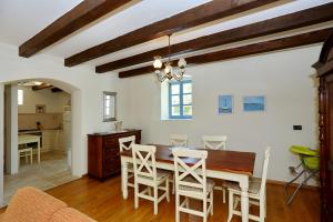 a kitchen and dining room with a table and chairs at Olive's Hug in Poljana