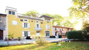 una gran casa amarilla con un patio delante en Château de la Prade, en Bram