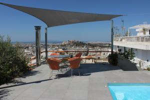 a balcony with chairs and a table and a swimming pool at Acropolis view penthouse in Athens