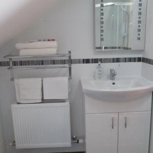 een witte badkamer met een wastafel en een spiegel bij Bonnieview in Glenross