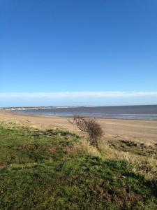 a sandy beach with the ocean in the background at For-Get-Me-Not Chalet semi detached in Bridlington