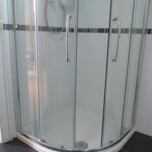a shower with a glass door in a bathroom at Bonnieview in Glenross