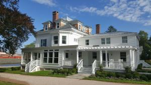 a large white house with a porch at Margin Street Inn in Westerly