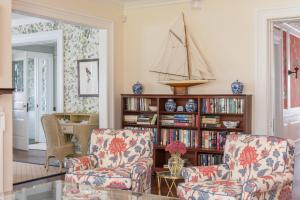a living room with two chairs and a book shelf at Margin Street Inn in Westerly