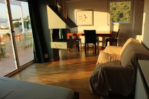 a living room with a couch and a dining room table at Acropolis view penthouse in Athens