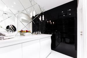 a bathroom with a white counter and a black wall at Dune B - FAF in Mielno +46 photos