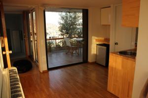 a kitchen with a sliding glass door leading to a balcony at Acropolis view penthouse in Athens