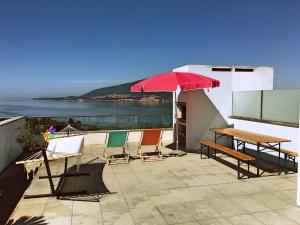 Un patio con una mesa y sillas y una sombrilla. en Terraços de Seixas, en Caminha