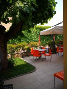 d'une terrasse avec une table et des chaises sous un parasol blanc. dans l'établissement La Stazione Camere Caffè, à Castiglione delle Stiviere