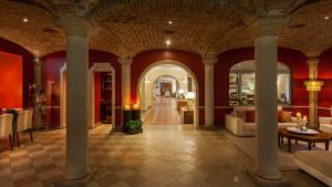 a living room with columns and red walls and a hallway at M'AR De AR Muralhas in Évora