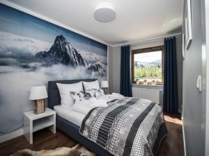 a bedroom with a bed with a painting of a mountain at Apartamenty Bawaria in Szklarska Poręba