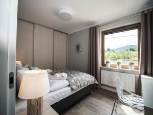 sypialnia z łóżkiem i oknem w obiekcie Apartamenty Bawaria w Szklarskiej Porębie