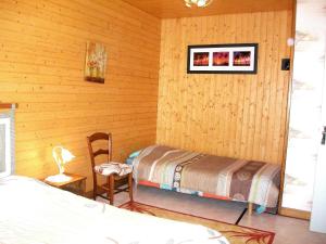 - une chambre avec un lit et une chaise dans l'établissement Gîte au cœur du Lot, la maison de Pauline, à Lentillac du Causse